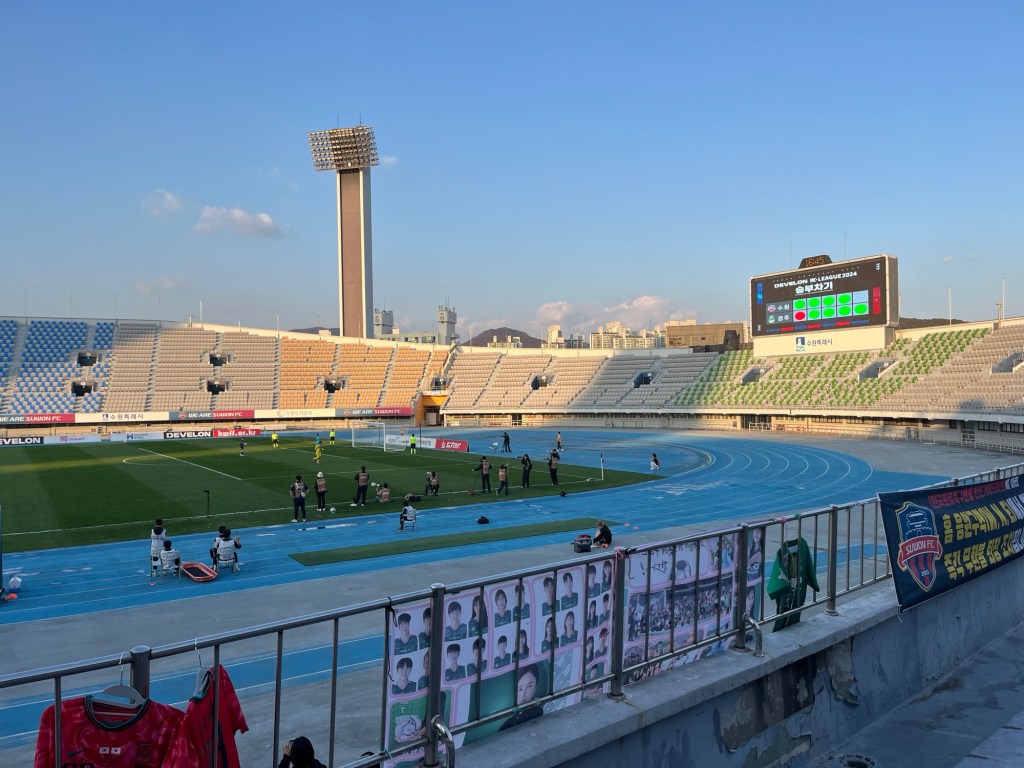 In a bowl shaped public stadium a penalty shootout is taking place between two women's football teams